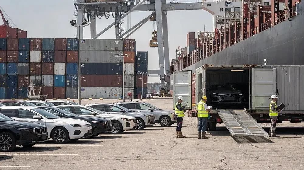Vehicle being loaded into a container at the terminal